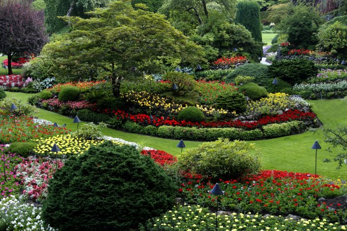 Gartenbau Gartengestaltung Landschaftsbau Bunte Blumenbeete mit gepflegten Wegen in einem gepflegten Garten.